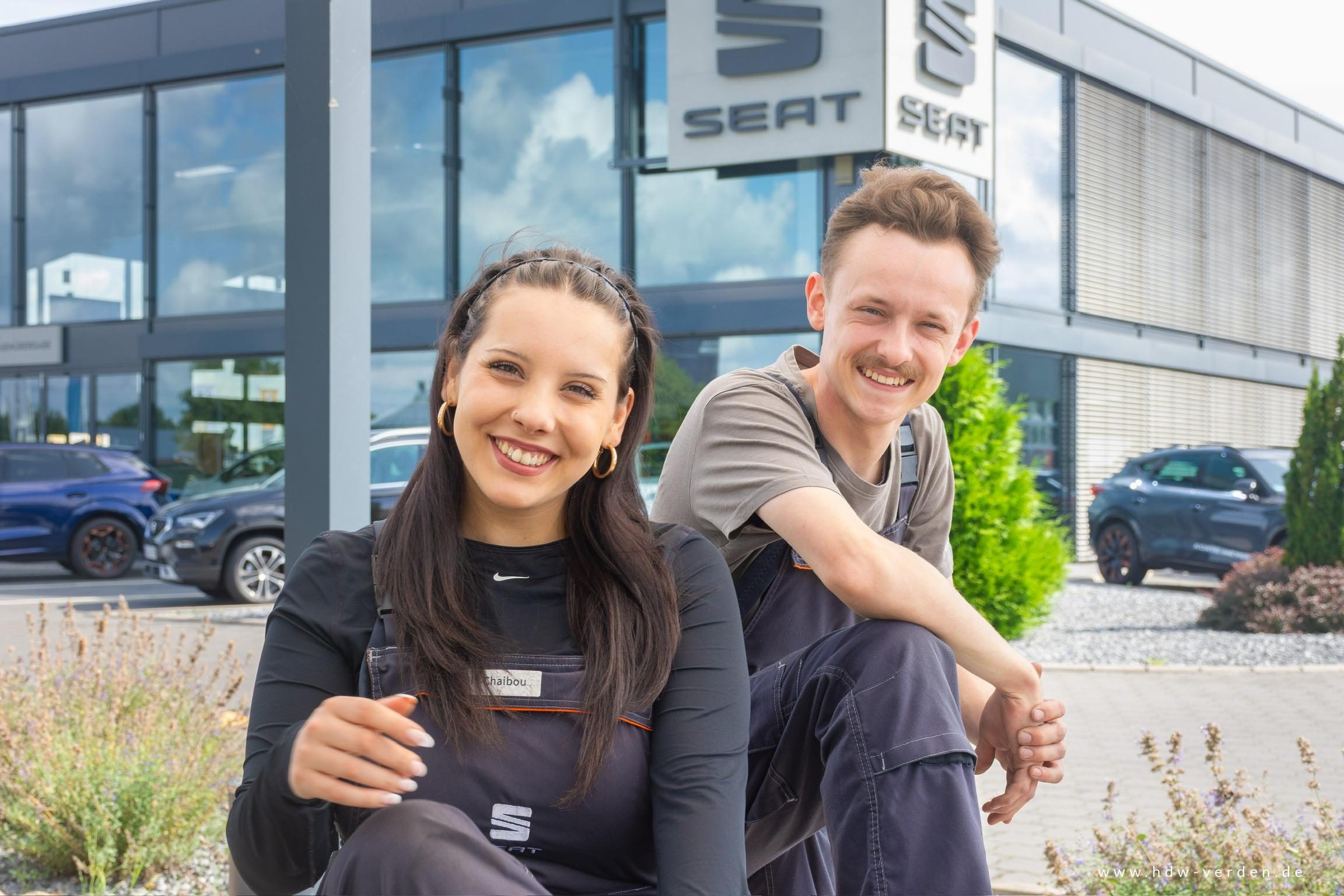 Zwei Auszubildende vor dem Autohaus